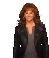 a woman with red hair is wearing a black jacket