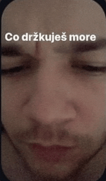 a close up of a man 's face with the words `` co drzkujes more '' written on it .