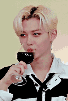 a young man drinking a glass of red wine