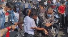 a group of people are sitting on motorcycles in a crowd of people .