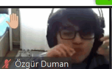 a man wearing glasses and headphones is on a video call with the name ozgur duman