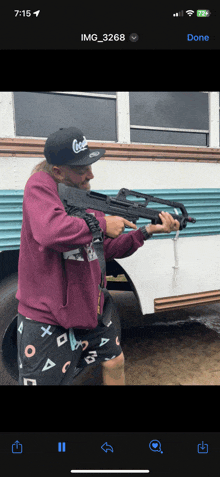 a man in a coca cola hat is holding a rifle in front of a bus