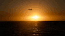 a seaplane is flying over the ocean at sunset