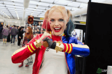 a woman in a harley quinn costume is smiling for the camera