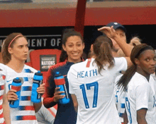 a group of female soccer players are standing in front of a sign that says " tournament of nations "