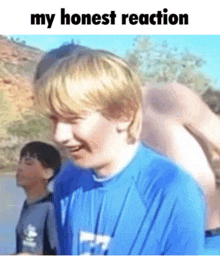 a young boy in a blue shirt is smiling with the words `` my honest reaction '' written above him .