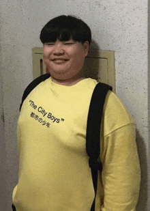 a young man wearing a yellow shirt that says the city boys