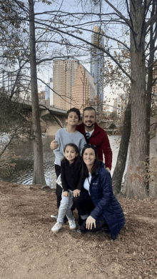 a family posing for a picture in front of a river