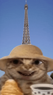 a cat wearing a hat and holding a cup of coffee in front of the eiffel tower