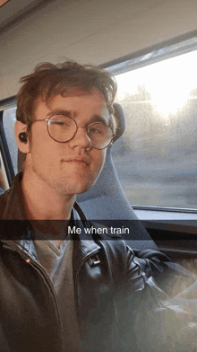 a man wearing glasses and a leather jacket is sitting in a car with the caption me when train