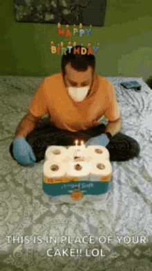 a man wearing a mask and gloves is sitting on a bed with a birthday cake made out of toilet paper