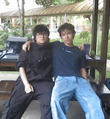 two young men are posing for a picture with one wearing a t-shirt that says ' t-shirt ' on it