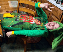 a person laying on a chair with a shirt that says ' christmas elf ' on it