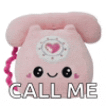 a pink stuffed telephone with a heart on it and the words `` call me '' written on it .