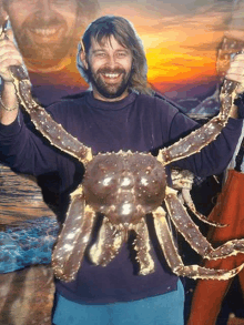 a man with a beard holds a large crab in his hands