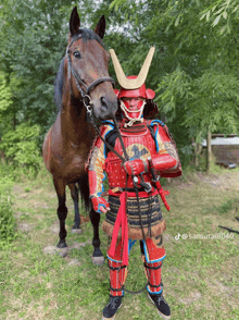 a man dressed as a samurai standing next to a horse