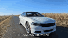 a white car is parked on the side of a road with brandan moment written on the bottom