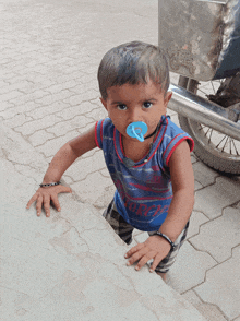 a young boy with a pacifier in his mouth wears a shirt that says scorpions