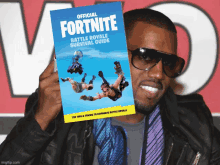 a man wearing sunglasses holds up a book titled official fortnite battle royale survival guide