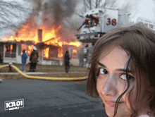 a girl stands in front of a burning house with kaoi memes written on the bottom