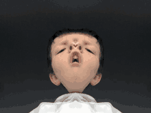 a close up of a child 's face with a white shirt around his neck