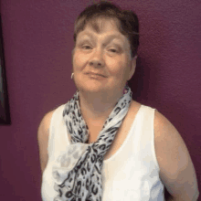 a woman wearing a scarf around her neck and a white tank top