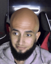 a man with a beard and a bald head is looking at the camera