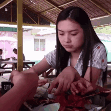 a woman sitting at a table with a plate of food and a sign that says ' i love you ' on it