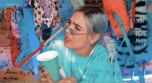 a woman holding a cup with a straw in front of a wall of math equations