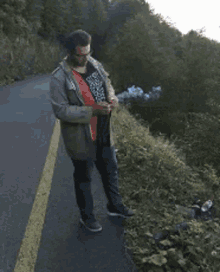 a man standing on the side of a road with his arms outstretched and smoke coming out of his mouth