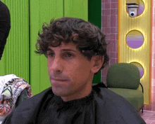 a man with curly hair is getting his hair cut by a hairdresser