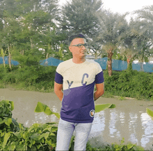 a man in a purple and white t-shirt with the letter c on it