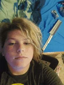 a young boy laying on a bed with a knife in his hand