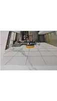 a white tile floor in a kitchen with a black mat on it .