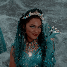 a woman in a mermaid costume with a tiara on her head