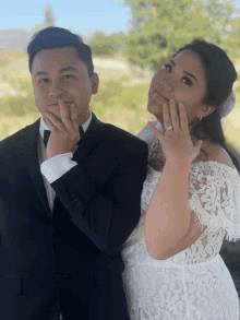 a man in a tuxedo and a woman in a white lace dress are posing for a photo