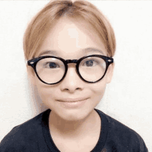 a young girl wearing glasses is smiling for the camera .