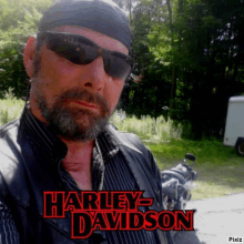 a man is wearing sunglasses and a harley davidson jacket