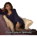 a woman is laying on a couch with pillows and a caption that says poses sexy in spanish .