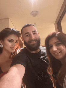 a man with a beard and two women pose for a picture