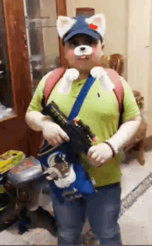 a man wearing a cat mask is holding a gun in a room .