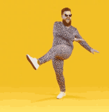 a man with a beard is wearing a leopard print outfit and sunglasses