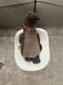 a stuffed penguin with a medal around his neck