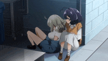 a couple of girls are sitting on the ground next to each other