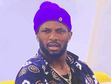 a man with a beard wearing a purple beanie and a black and white shirt