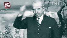 a man in a suit and tie is saluting in a black and white photo