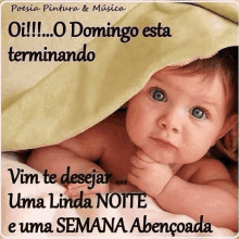 a baby is laying under a blanket with a message in portuguese .