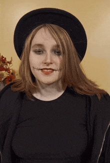 a woman wearing a black hat has stitches in her mouth