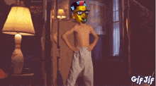 a shirtless boy wearing a swag mask and sunglasses is standing in a room with his hands on his hips .