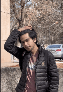 a man wearing a black jacket and a t-shirt that says nm